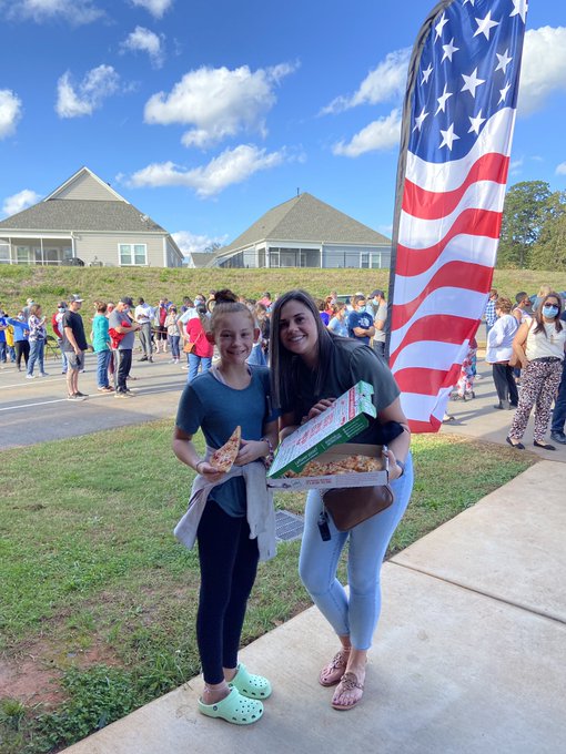 Mother and daughter enjoying pizza in front of American flag